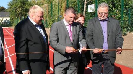 Der Landtagsabgeordnete Ronald Mormann, Landrat Uwe Schulze, Schuldirektor Armin Freyer (v.l.) und die Landtagsabgeordnete Brigitte Take (hinten) bei der symbolische Übergabe der Außensportanlage.