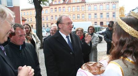 Zwei Studentinnen reichen Sachsen-Anhalts Ministerpräsident Dr. Reiner Haseloff Brot zur Begrüßung.