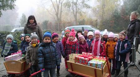 Erzieherin Kerstin Sagasser (l.), Kita-Leiterin Ines Lüttig (r.) und die Mädchen und Jungen der Marienkäfer-Gruppe der Kita Spielkiste brachten zwei Wagenladungen voll Geschenke.