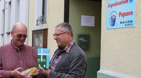 Der Leiter des Jugendclubs, Olaf Schwertfeger, erhielt von Pfarrer Horst Leischner ein paar Geschenke zum Einzug in die neuen Räumlichkeiten.