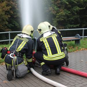 Feuerwehrkameraden löschen ein Feuer.