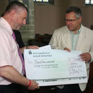 Landrat Uwe Schulze überreichte Pfarrer Horst Leischner einen symbolischen Scheck in Höhe von 5.000 Euro.