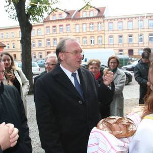 Zwei Studentinnen reichen Sachsen-Anhalts Ministerpräsident Dr. Reiner Haseloff Brot zur Begrüßung.