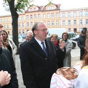 Zwei Studentinnen reichen Sachsen-Anhalts Ministerpräsident Dr. Reiner Haseloff Brot zur Begrüßung.